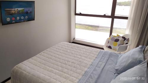 累西腓Flat Barra Home Stay, 307. Conforto e natureza.的一间卧室配有一张带窗户和椅子的床