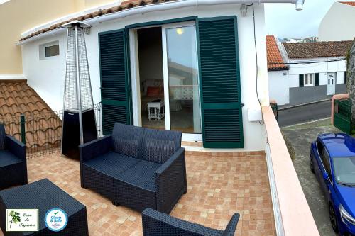 eine Terrasse mit einem Sofa und Stühlen auf einer Terrasse in der Unterkunft Alojamento CASA DA FIGUEIRA in Ponta Delgada