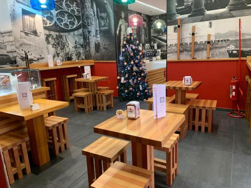 un ristorante con tavoli in legno e un albero di Natale di Neapolis Lifestyle a Napoli