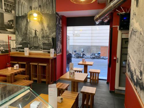 een restaurant met houten tafels en banken en een raam bij Neapolis Lifestyle in Napels