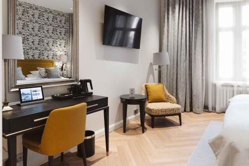 een hotelkamer met een bureau en een bed en een slaapkamer bij Hotel Bastian in Helsinki