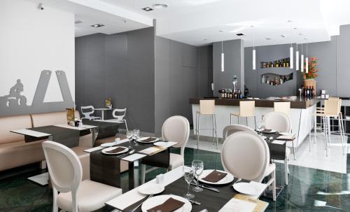 a restaurant with white chairs and tables and a bar at Catalonia Atocha in Madrid