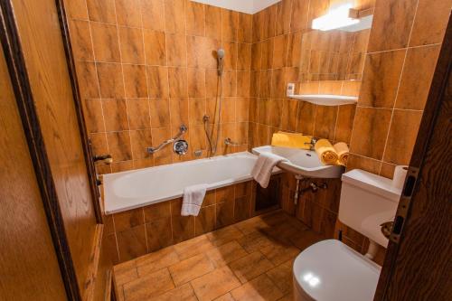 a bathroom with a tub and a toilet and a sink at Huberhof 7 by Alpenidyll Apartments in Schladming