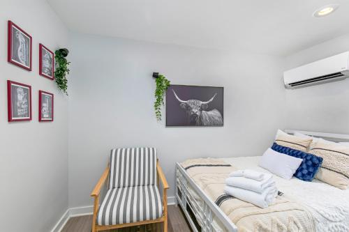 a white bedroom with a bed and a chair at East Nashville Nook Best of Both Worlds in Nashville