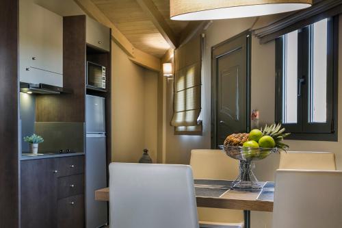 a kitchen with a table with a bowl of fruit on it at Crystal Palace - Luce in Skala Kefalonias