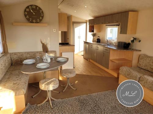 eine Küche und ein Wohnzimmer mit Tisch und Stühlen in der Unterkunft Meadow View 81 - Golden Palm, Central Heating, WiFi, pet friendly - Meadow Lakes Caravan & Lodge Hire in Chapel Saint Leonards
