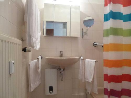 a bathroom with a sink and a mirror and towels at DKK7 Ferienwohnung Abendsonne F in Niendorf