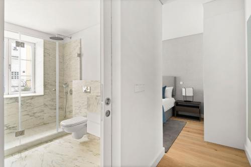 uma casa de banho branca com um WC e um chuveiro em Mirabilis Apartments - AAA23 em Lisboa