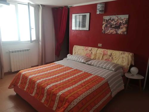 een slaapkamer met een bed en een rode muur bij La Casa Del Peperoncino Rosso in Quartu SantʼElena