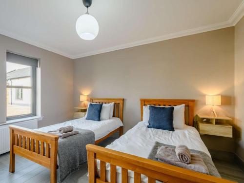 a bedroom with two beds and a window at Westertonhill Lodge 3 with Hot Tub Option in Balloch