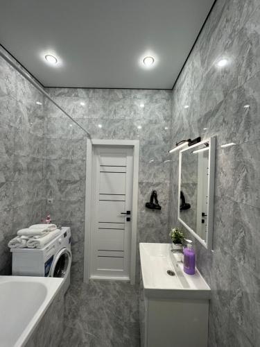 een badkamer met een wastafel en een wasmachine. bij Апартаменты Миллениум 2 in Astana