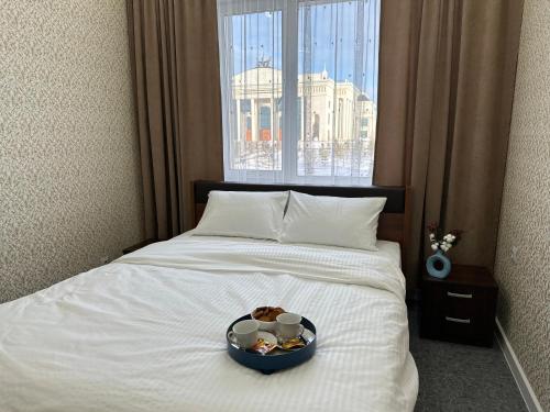een kom eten op een bed met een raam bij Апартаменты Миллениум 2 in Astana