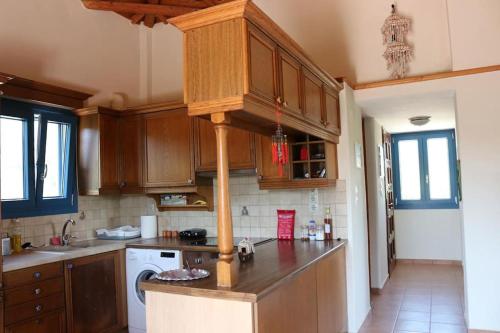 cocina con armarios de madera y encimera en VILLA Michalis, en Kokkari