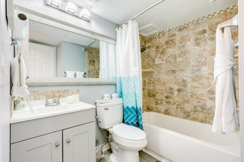 a bathroom with a toilet and a sink and a tub at Casa Del Mar Skip to the Beach 294 in Galveston