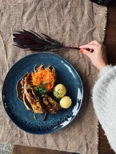 a plate of food on a table with a person holding a fork at Tabun in Gdańsk