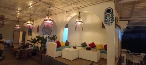 a living room with a couch and chandeliers at Footloose Hostel in Vagator