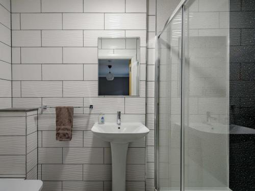 y baño blanco con lavabo y ducha. en Westertonhill Lodge 8 Newbuild with Hot Tub Option, en Balloch