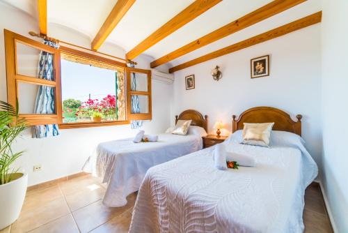 2 camas en una habitación con ventana en Ideal Property Mallorca - Moli, en Port de Pollença (Puerto Pollensa)