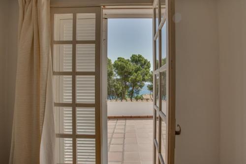 eine offene Tür zu einem Balkon mit Meerblick in der Unterkunft Ideal Property Mallorca - Padri in Font de Sa Cala
