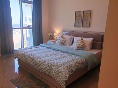 1 dormitorio con 1 cama grande y ventana grande en LUXURIOUS SEA VIEW APARTMENT FOR STAYS!, en Ajman