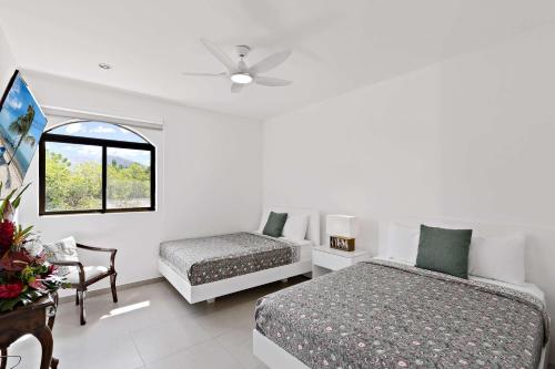 a white bedroom with two beds and a window at Bougainvillea 4315 PH- Luxury 3 Bedroom Ocean View Resort Condo in Brasilito