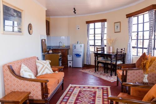 een woonkamer met een bank en een tafel bij Wild Amboseli Ndovu Cottage. in Amboseli
