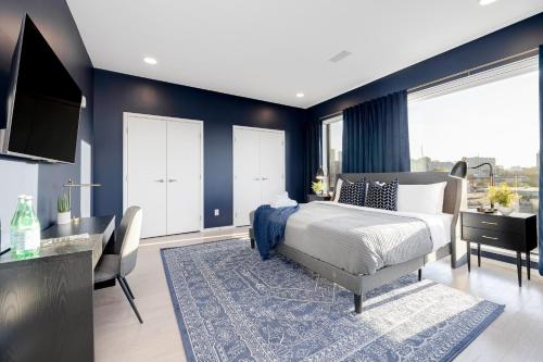 a bedroom with blue walls and a bed and a desk at 700 1st Ave N Unit 507 in Nashville