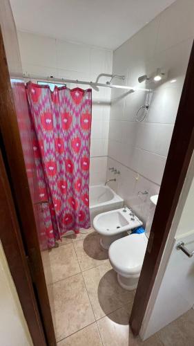 baño con 2 aseos y cortina de ducha roja en Duplex Casnati en San Rafael