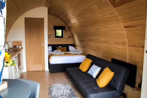 um quarto com uma cama e um sofá num quarto em Cwm Hapus em Knighton