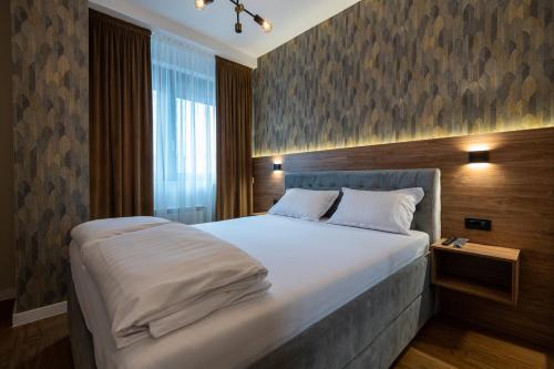 - une chambre avec un grand lit blanc dans l'établissement GRAND LUX APARTMENTS, à Banja Luka