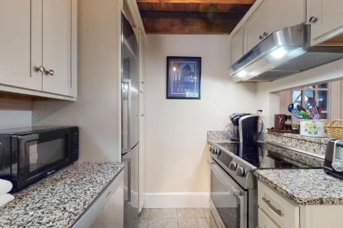 a kitchen with white cabinets and granite counter tops at Quechee Hollow Comfort in White River Junction