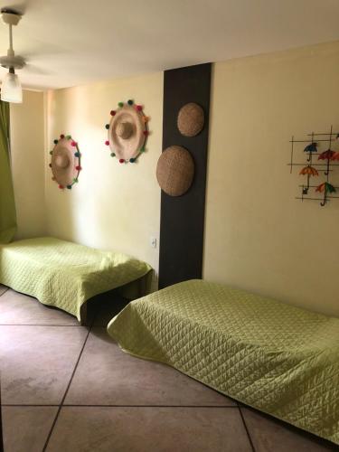 a bedroom with two beds and decorations on the wall at Casa da Rô !!! Melhor casa frente ao mar de Ubu !!! in Anchieta
