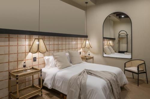 1 dormitorio con 1 cama blanca grande y espejo en Privado Selfservice Boutique Rooms, en Cartagena de Indias