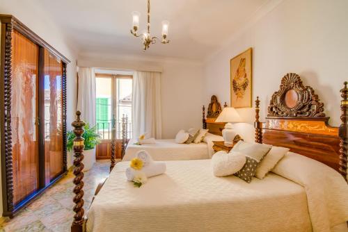 a bedroom with two beds and a chandelier at Ideal Property Mallorca - Binibonaire 2 PAX in Binissalem