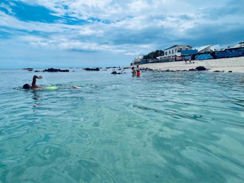 a woman laying on a boogie board in the water on a beach at Villa Maimouna les pieds dans l'eau in Saint-Pierre
