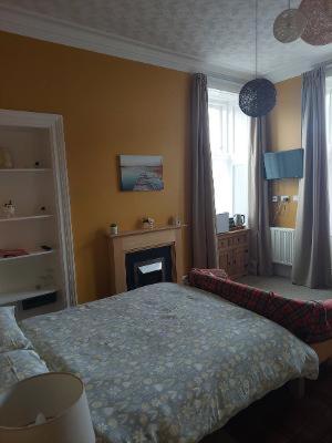 a bedroom with a bed and a fire place at Bank House in Thurso