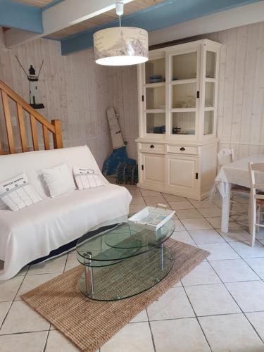a living room with a couch and a glass table at penty vero in Plobannalec-Lesconil