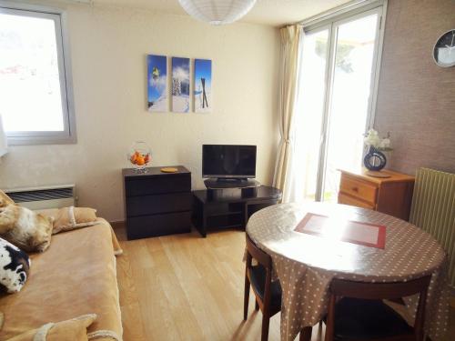 un salon avec une table et un canapé dans l'établissement Appartement cosy au pied des pistes avec parking - FR-1-516-43, à Les Deux Alpes