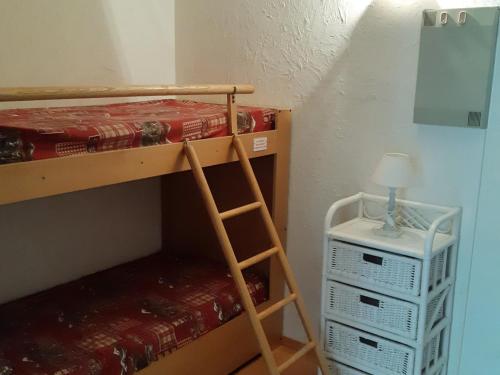 a bunk bed with a ladder and a night stand at Studio Les Deux Alpes, 1 pièce, 4 personnes - FR-1-516-51 in Les Deux Alpes