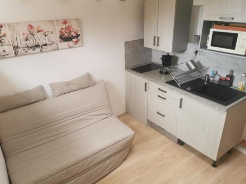 une petite cuisine avec un canapé et un évier dans l'établissement T2 équipé au calme + Terrasse à 1 km de la Mer, à Marseille