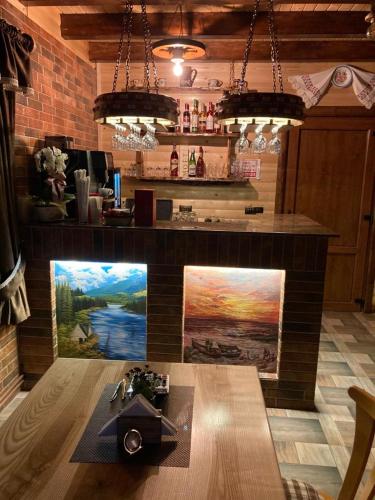 a bar in a restaurant with a painting on the wall at Căsuța - La Țanc in Martinie