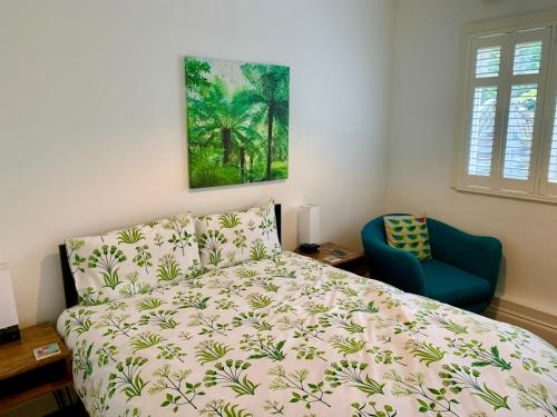 a bedroom with a bed and a blue chair at Derrin Guest House in Larne