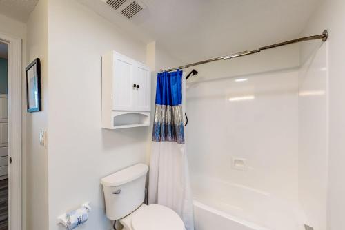 ein weißes Bad mit einem WC und einer Dusche in der Unterkunft Water's Edge 301 in Fort Walton Beach