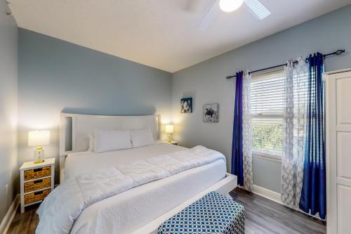 Un dormitorio con una gran cama blanca y una ventana en Water's Edge 301, en Fort Walton Beach
