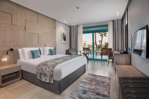 シャルム・エル・シェイクにあるPyramisa Beach Resort Sharm El Sheikhのベッドとバルコニー付きのホテルルーム