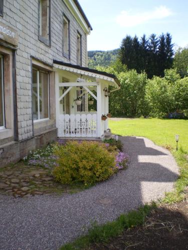 a house with a porch with a white fence at Chambres d'Hôtes le Clos des Lesses in Fresse-sur-Moselle