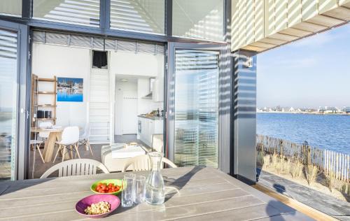 a dining room with a table with a view of the water at Waterrijk Oesterdam Resort Villas in Tholen