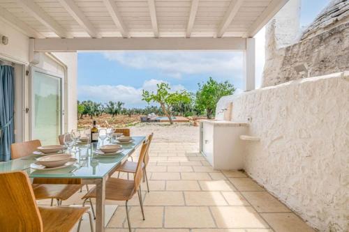 a patio with a table and chairs and a refrigerator at Bianco Trullo by Raro Villas in Latiano