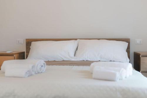 a bed with white pillows and towels on it at Bianco Trullo by Raro Villas in Latiano