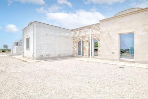 a large white brick building with a large driveway at Bianco Trullo by Raro Villas in Latiano